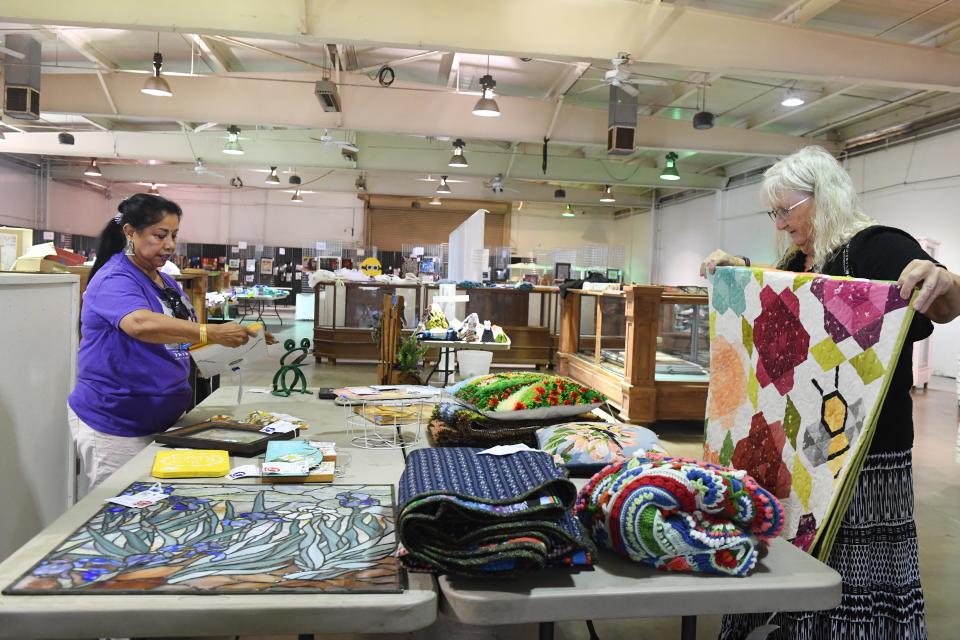 Valerie Myers, left, and Judi Ulmer organize exhibit items in the Home Arts building at the Ventura County Fairgrounds as post-fair cleanup started Monday.