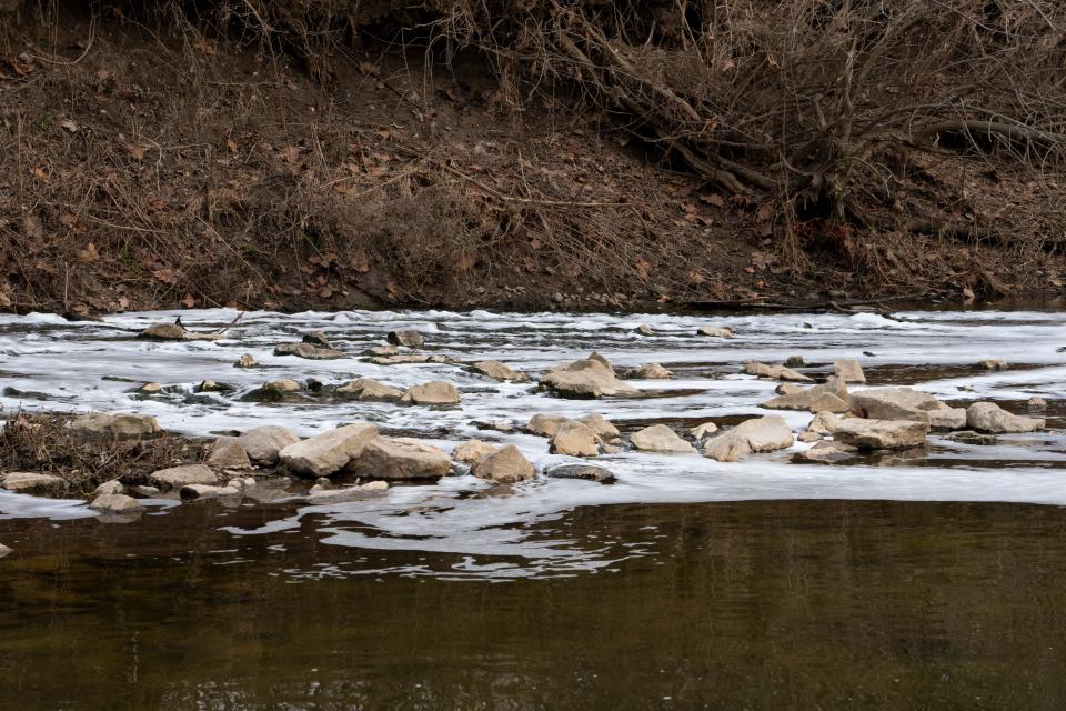 A foamy substance streams out of a combined sewage discharge overflow point into Eagle Creek Wednesday, Feb. 21, 2024, from the Speedway Wastewater Treatment Plant.