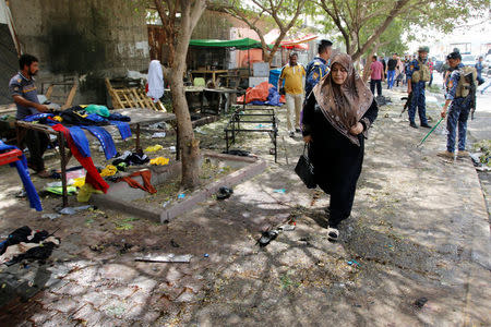 A woman walks past at the site where a suicide bomber detonated his explosive vest at the entrance to Kadhimiya, a mostly Shi'ite Muslim district in northwest Baghdad, Iraq July 24, 2016. REUTERS/Khalid al Mousily