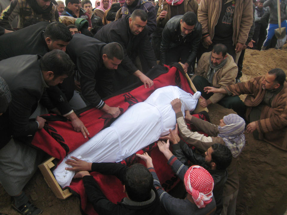 Mourners prepare to bury the body of Mahmoud Abdullah, who was killed in a mortar attack, at the cemetery in Fallujah, Iraq, Tuesday, Jan. 14, 2014. Violence has been on the rise in Iraq recently as security forces and allied Sunni tribesmen in Anbar province battle al-Qaida fighters over the control of two key cities there. (AP Photo)