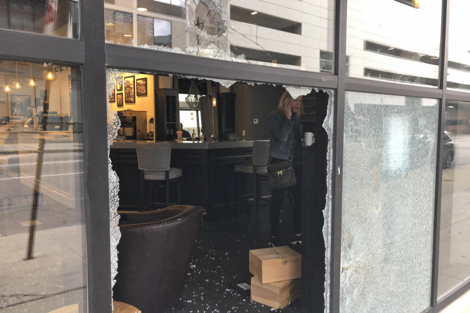 Monica Thomas, franchise owner of Winan's Chocolates + Coffees + Wine, talks on the phone inside her smashed up shop on Friday, May 29, 2020, in Columbus, Ohio. The damage happened early Friday as protesters angry over the death of George Floyd in Minneapolis police custody turned out for a demonstration in Columbus that began peacefully but turned violent, with windows smashed at the Ohio Statehouse and storefronts along surrounding downtown streets. (AP Photo/Andrew Welsh-Huggins)