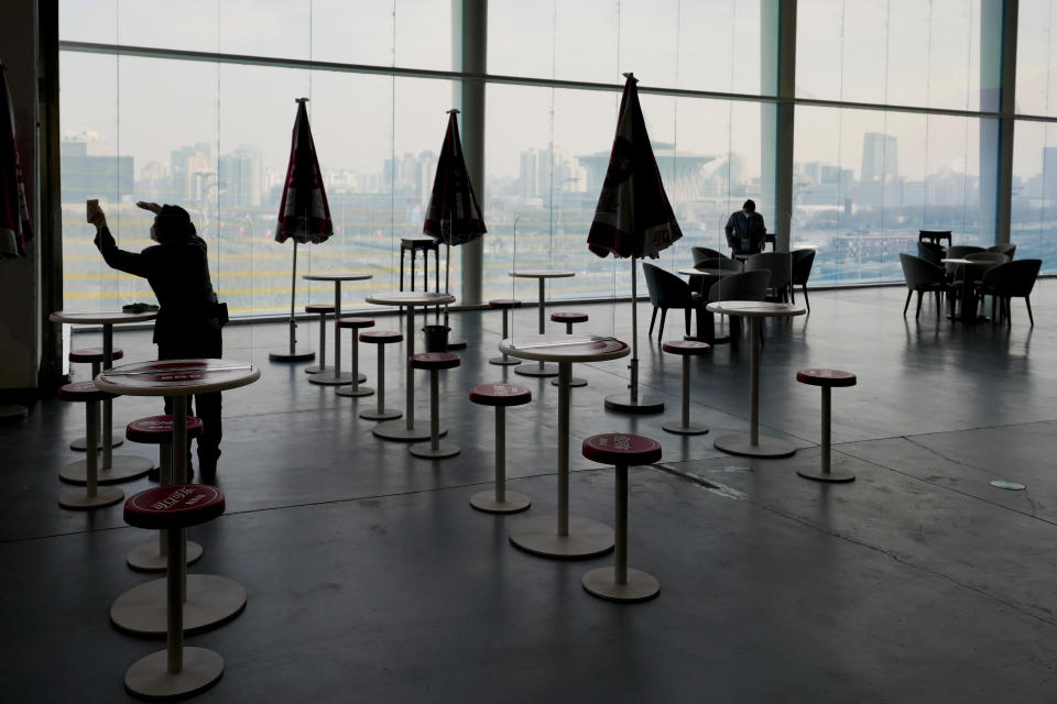 Workers cleaning a dining area inside the main media center as preparations are underway for the Beijing Winter Olympics Tuesday, Jan. 18, 2022, in Beijing. (AP Photo/Denis Paquin)