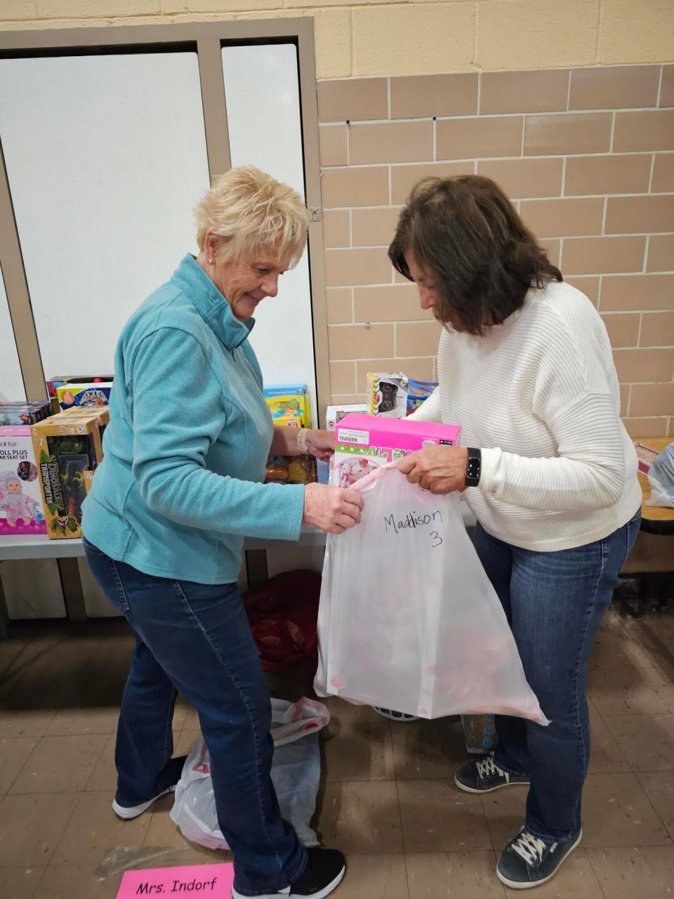 Volunteers Sue Nelson, left, and Margaret Cockling pack bags with toys as part of the Massillon City Schools and AHEAD Inc.'s Christmas giveaway. The group will provide gifts to about 150 kids this season.