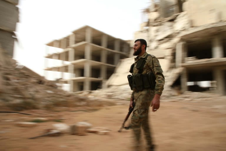 A Syrian rebel-fighter from the National Liberation Front walks in a street in the rebel-held Al-Rashidin district of western Aleppo's countryside near Idlib province, on October 15, 2018