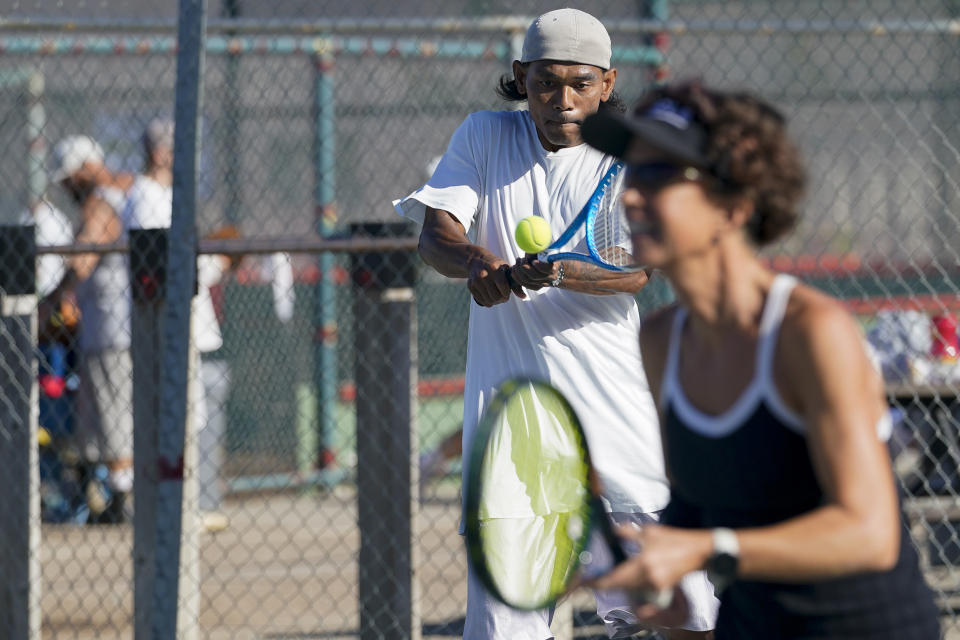 James Duff, an inmate at San Quentin State Prison, hits a return while playing tennis alongside Associated Press sports reporter Janie McCauley, foreground, in San Quentin, Calif., Saturday, Aug. 13, 2022. (AP Photo/Godofredo A. Vásquez)