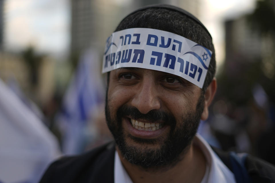 A man wears a sticker that reads: "the people have chosen reform,"as right-wing Israelis rally in support of Prime Minister Benjamin Netanyahu's government plans to overhaul the judicial system, in Tel Aviv, Israel, Thursday, March 30, 2023. (AP Photo/Ariel Schalit)