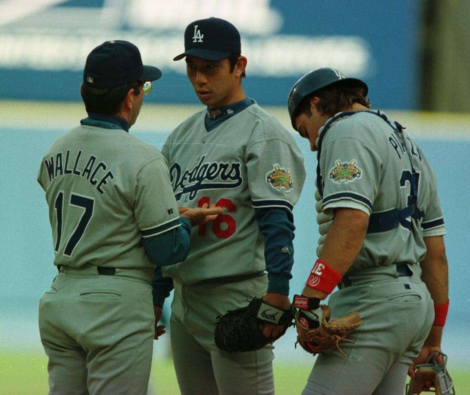 Dodgers pitcher Hideo Nomo speaks to pitching coach David Wallace after giving up a home run to Atlanta's Chipper Jones.