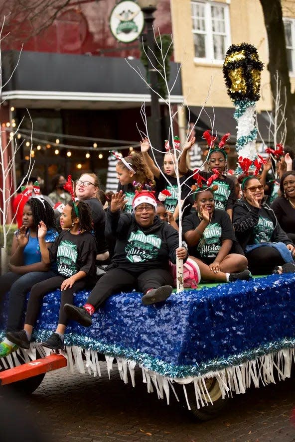 Members of the Diamond Xtreme Allstars sports club ride on the group's float during the  2021 Rotary Christmas Parade in historic downtown Fayetteville. Organizers say safety precautions are in place for this year's parade.