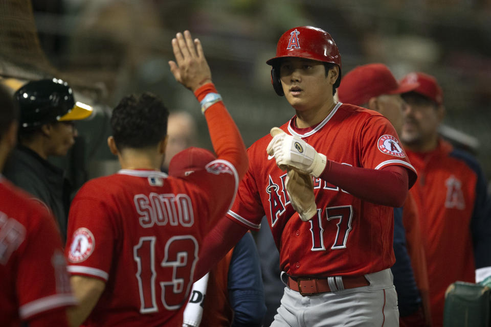 Los Angeles Angels designated hitter Shohei Ohtani (17) is greeted by his teammates after he scored on a double by Taylor Ward during the fifth inning of a baseball game against the Oakland Athletics, Monday, Oct. 3, 2022, in Oakland, Calif. (AP Photo/D. Ross Cameron)