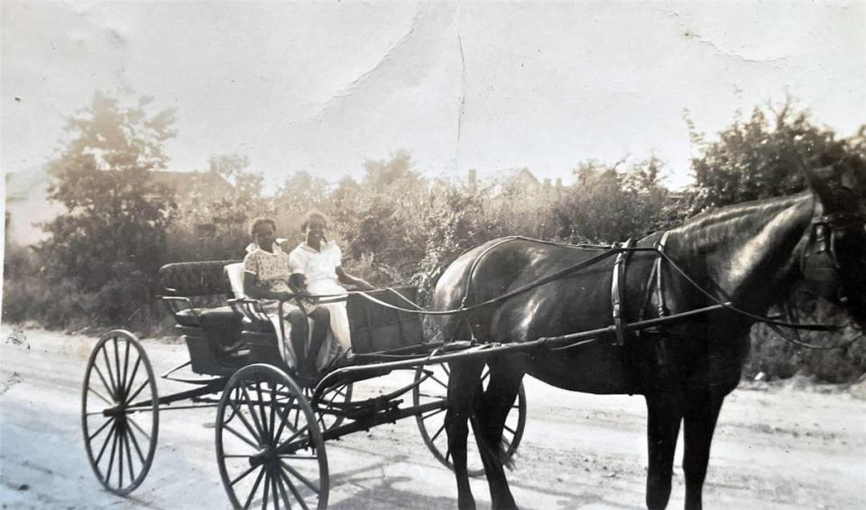 Cousins Dolores Clark and Georgia Bradsher are seen riding in a horse-drawn carriage in Carrboro, N.C. in this family photograph.