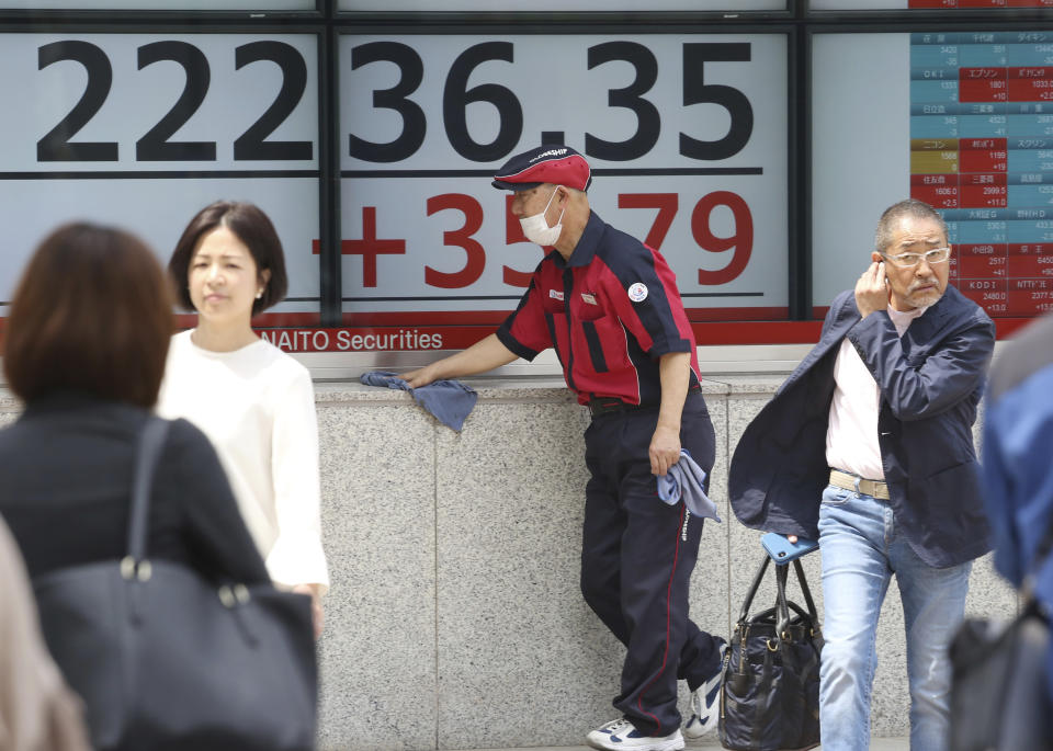 People walk by an electronic stock board of a securities firm in Tokyo, Monday, April 22, 2019. Asian stock markets were mixed Monday following the Easter holiday weekend as investors looked ahead to U.S. and Japanese economic data. (AP Photo/Koji Sasahara)