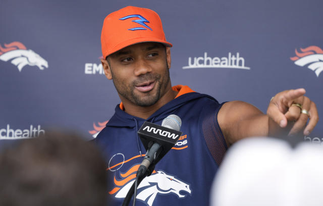 Denver Broncos quarterback Russell Wilson tosses out the first pitch during  ceremonies to mark the regular-season home opener as the Colorado Rockies  host the Los Angeles Dodgers in a baseball game Friday