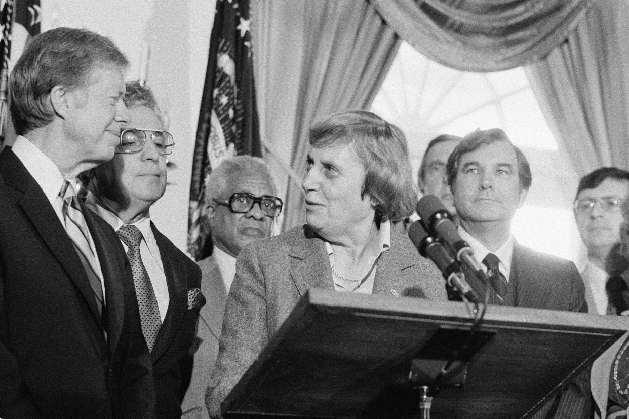 Connecticut Gov. Ella Grasso speaks at a bill signing ceremony at the White House in Washington on Nov. 27, 1979. President Jimmy Carter signed a bill providing $1.35 billion to help the poor pay fuel bills. Next to the president is Rep. Mario Biaggi, D-N.Y. Man in background is unidentified.