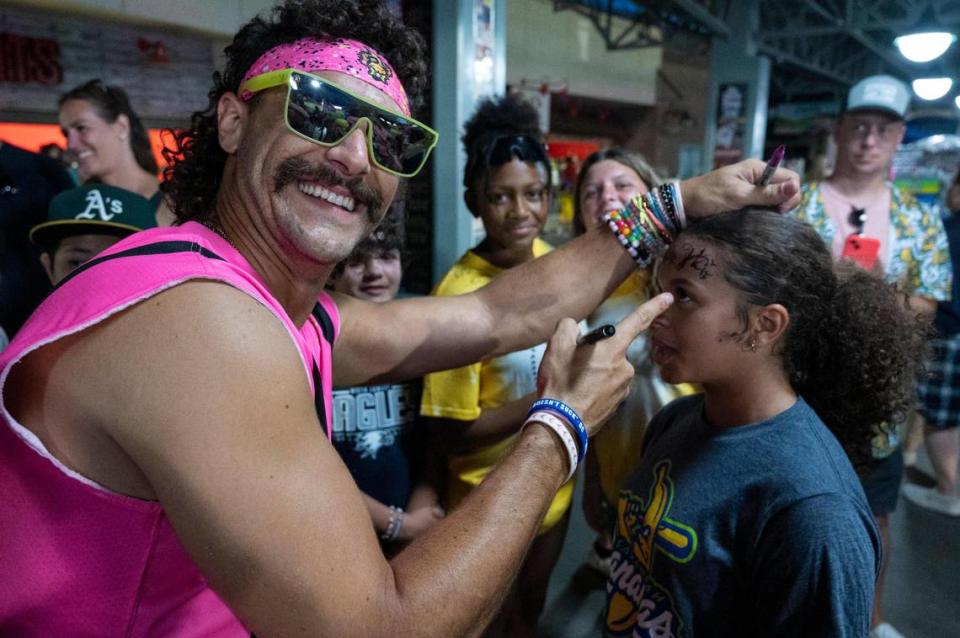 Erica Banks, 12, gets her forehead signed by Savanna Party Animals’ Joe Lytle (22) during the Savannah Bananas World Tour on Saturday, July 29, 2023, at Sutter Health Park in West Sacramento.
