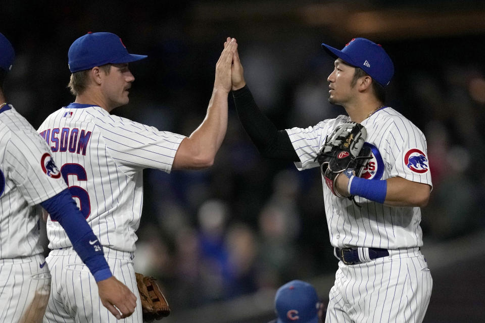 Chicago Cubs' Patrick Wisdom, left, and Seiya Suzuki celebrate the team's 17-3 win over the Washington Nationals in a baseball game Tuesday, July 18, 2023, in Chicago. (AP Photo/Charles Rex Arbogast)