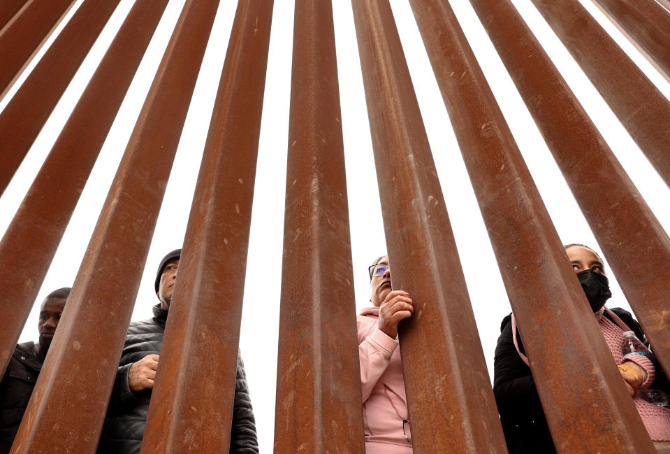 Immigrants seeking asylum in the U.S., who are stuck in a makeshift camp amongst the border walls between the U.S. and Mexico, look through the border wall on May 13, 2023 in San Diego, California. / Credit: / Getty Images