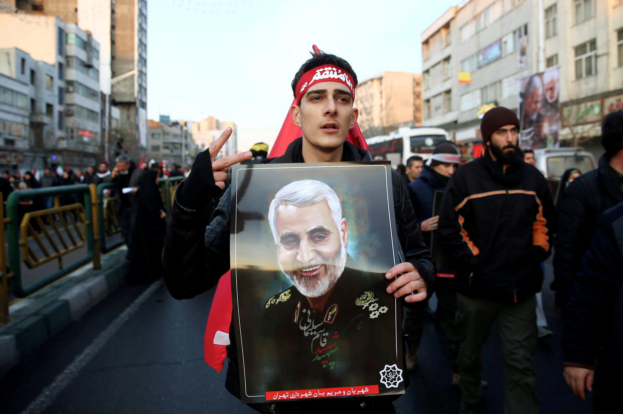 An Iranian man holds a picture of Qassem Soleimani during a funeral procession for Iranian Major-General Qassem Soleimani, head of the elite Quds Force, and Iraqi militia commander Abu Mahdi al-Muhandis, who were killed in an air strike at Baghdad airport, in Tehran, Iran January 6, 2020. Nazanin Tabatabaee/WANA (West Asia News Agency) via REUTERS ATTENTION EDITORS - THIS IMAGE HAS BEEN SUPPLIED BY A THIRD PARTY