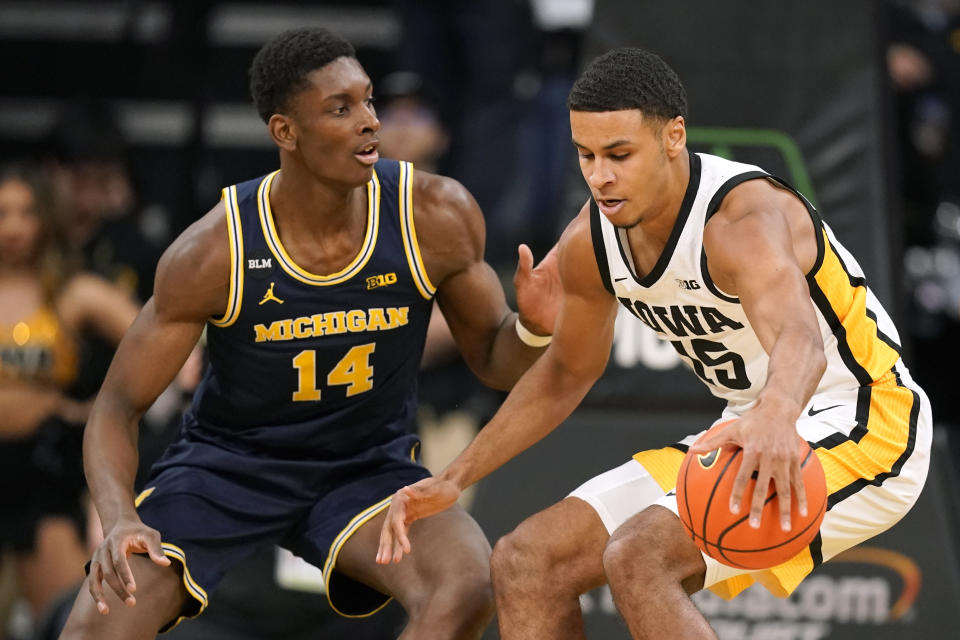 Iowa forward Keegan Murray (15) drives around Michigan forward Moussa Diabate (14) during the first half of an NCAA college basketball game, Thursday, Feb. 17, 2022, in Iowa City, Iowa. (AP Photo/Charlie Neibergall)