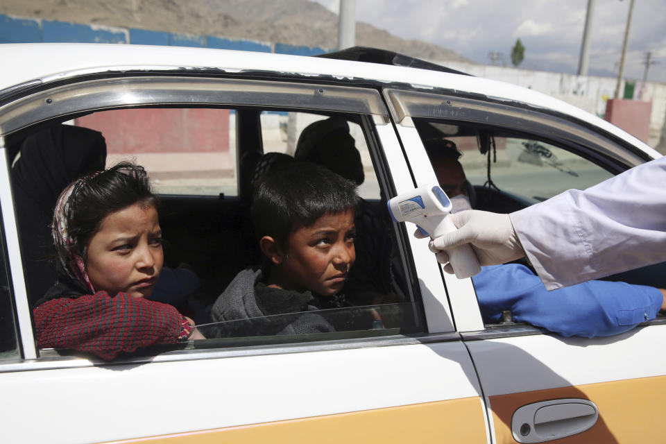 A health worker checks the temperature of passengers in an effort to help prevent the spread of the coronavirus, as they enter the city in the Paghman district of Kabul, Afghanistan, Sunday, May 3, 2020. (AP Photo/Rahmat Gul)