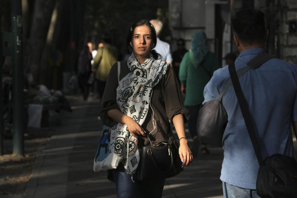 An Iranian woman walks Tehran, Iran, Saturday, Aug. 5, 2023. These days, with uncovered women a common sight on Tehran streets, authorities have begun raiding companies where women employees or customers have been seen without the headscarf, or hijab. Iran's parliament is discussing a law that would increase punishments on uncovered women and the businesses they frequent. (AP Photo/Vahid Salemi)