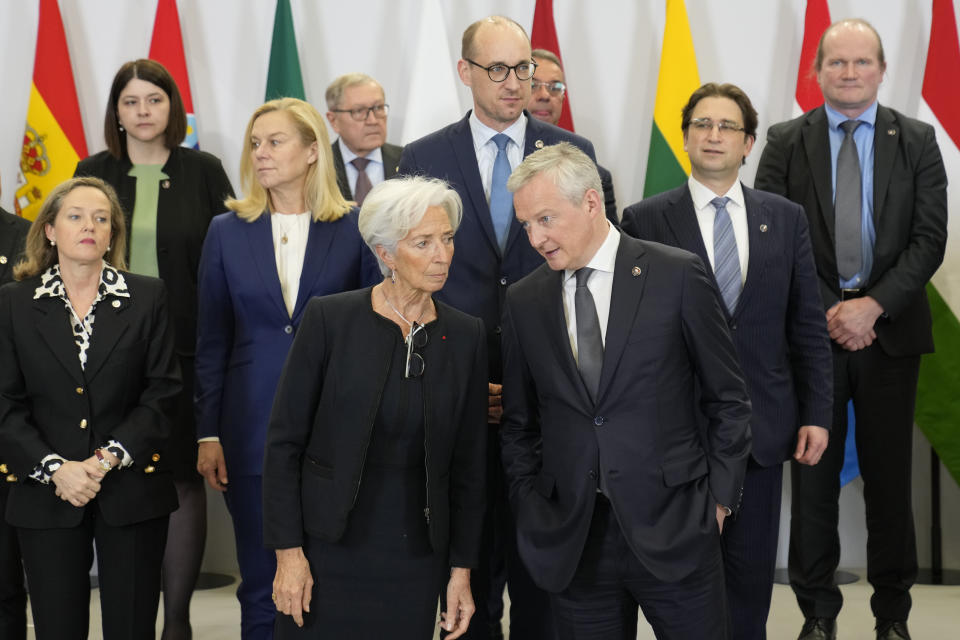 French Economy minister Bruno Le Maire, right, talks with President of European Central, Bank Christine Lagarde as they pose for a family picture during a European Finance Ministers meeting, Friday, Feb. 25, 2022 in Paris. European Union leaders put on a united front after a six-hour meeting that went into early Friday morning, during which they agreed on a second package of economic and financial sanctions against Russia. (AP Photo/Francois Mori)