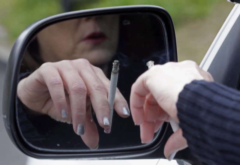 This photo shows a woman smoking a cigarette in her vehicle. It’s not clear whether the person ticketed in British Columbia for reportedly throwing a cigarette out of a car window was a woman or a man.