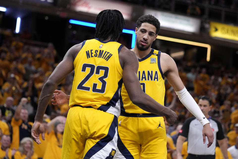 Indiana Pacers forward Aaron Nesmith (23) celebrates with teammate guard Tyrese Haliburton after a dunk during the second half of Game 6 against the New York Knicks in an NBA basketball second-round playoff series, Friday, May 17, 2024, in Indianapolis. (AP Photo/Michael Conroy)