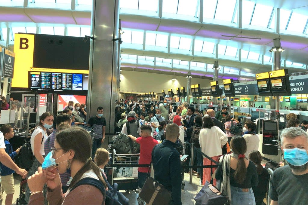 Travellers queuing  Heathrow Airport this summer (PA)