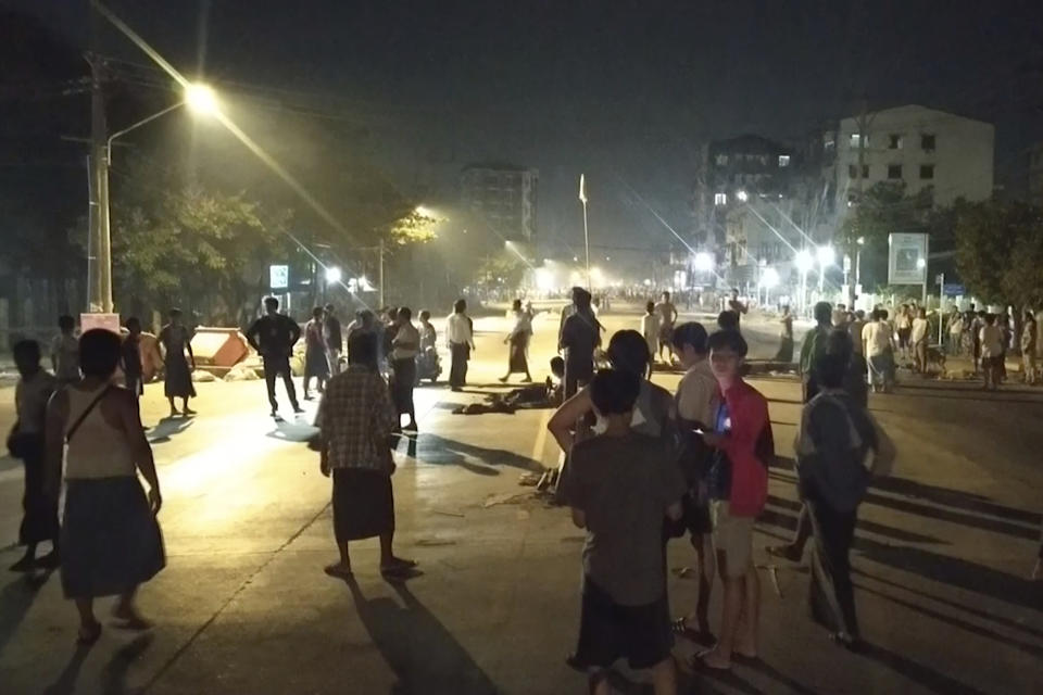 In this image taken from video, people stand outside their homes and gather together on a road in Insein township in Yangon, Myanmar, Monday, March 8, 2021. Demonstrators in Myanmar’s biggest city came out Monday night for their first mass protests in defiance of an 8 p.m. curfew, seeking to show support for an estimated 200 students trapped by security forces in a small area of one neighborhood. (AP Photo)