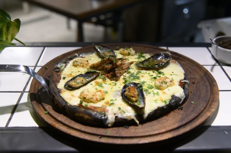 La pizza con tinta de calamar y mariscos se convirtió en un clásico que no puede faltar en la carta