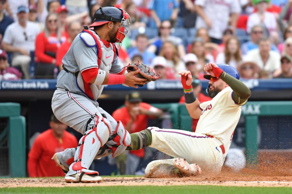 Philadelphia Phillies designated hitter Kyle Schwarber (12) slides safely into home ahead of tag by Washington Nationals catcher Keibert Ruiz (20) during the fifth inning Sunday, May 19, 2024, at Citizens Bank Park in Philadelphia.