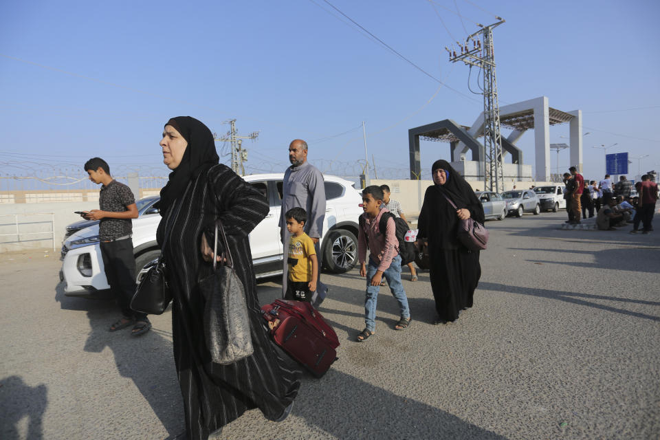 Palestinos esperan en el cruce fronterizo entre la Franja de Gaza y Egipto, en Rafah, el 1 de noviembre de 2023. (AP Foto/Hatem Ali)