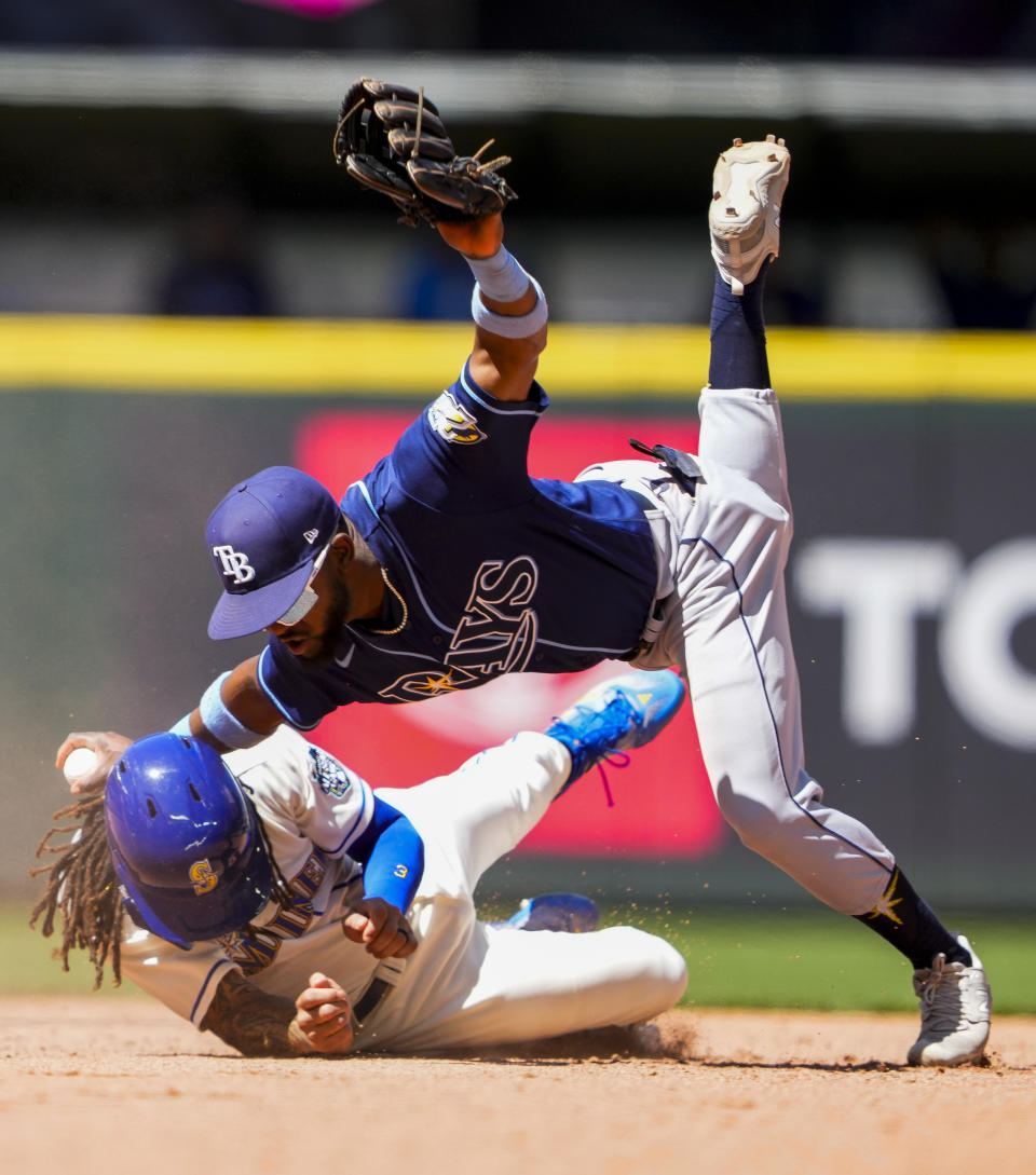 Tampa Bay Rays second baseman Vidal Brujan falls as he forces out Seattle Mariners' J.P. Crawford at second base on a fielder's choice hit by Julio Rodriguez during the sixth inning of a baseball game, Sunday, July 2, 2023, in Seattle. (AP Photo/Lindsey Wasson)