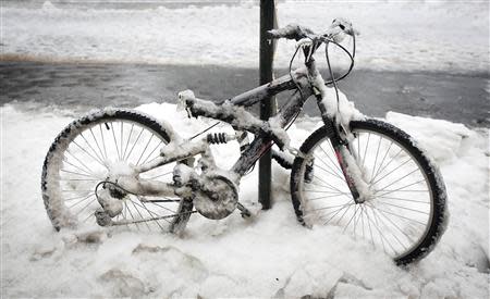 A snow covered bicycle is pictured in the rain in the Manhattan borough of New York February 5, 2014. REUTERS/Carlo Allegri