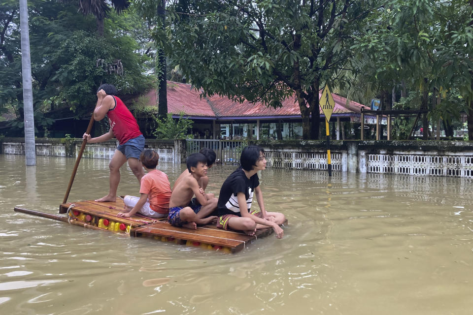 Local residents use a raft to pass a flooded road in Bago, about 80 kilometers (50 miles) northeast of Yangon, Myanmar, Monday, Oct. 9, 2023. Flooding triggered by heavy monsoon rains in Myanmar’s southern areas has displaced more than 10,000 people and disrupted traffic on the rail lines that connect the country’s biggest cities, officials and state-run media said Monday. (AP Photo/Thein Zaw)