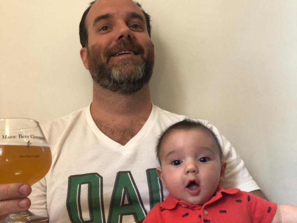 Man holding a baby and a beer