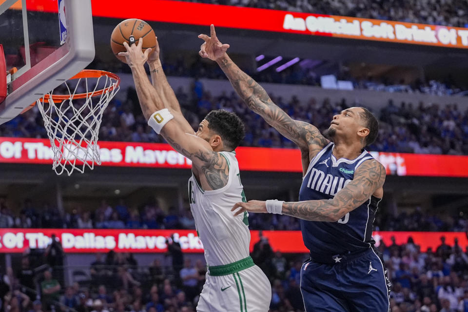 Boston Celtics forward Jayson Tatum, left, scores a basket in front of Dallas Mavericks forward P.J. Washington during the second half in Game 3 of the NBA basketball finals, Wednesday, June 12, 2024, in Dallas. (AP Photo/Tony Gutierrez)