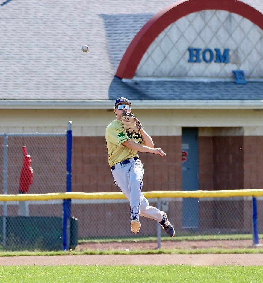 Batavia Notre Dame third baseman attempts to throw out a runner against Akron.