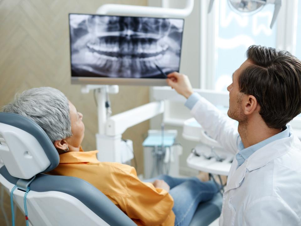 Dentist and patient looking at an X-ray of teeth