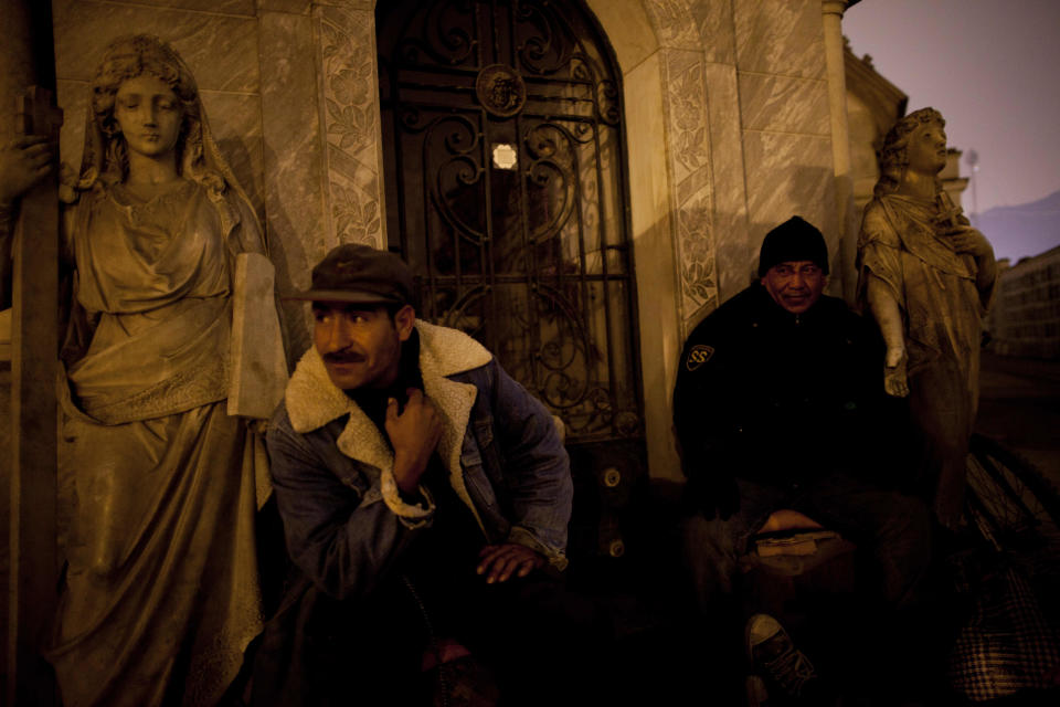 In this Nov.10, 2012 photo, private security guards watch visitors take a nighttime guided tour through the Presbitero Matias Maestro cemetery in Lima, Peru. The cemetery, created by one of the last Spanish viceroys, was established the outside the walls of old Lima. (AP Photo/Rodrigo Abd)