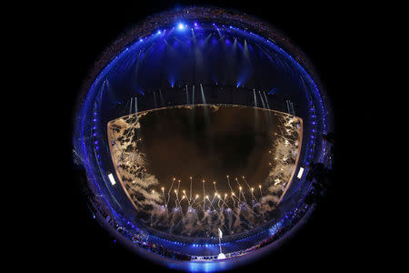 Fireworks explode over the stadium in this photo taken with a fish-eye lens during the opening ceremony for the 2014 Commonwealth Games at Celtic Park in Glasgow, Scotland, July 23, 2014. REUTERS/Jim Young