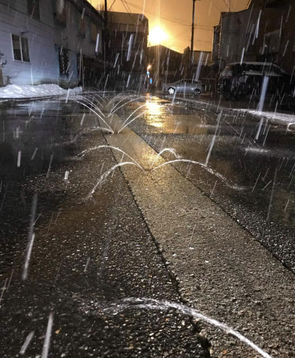 Sprinklers in the middle of the road spray saltwater in four directions to cover the street