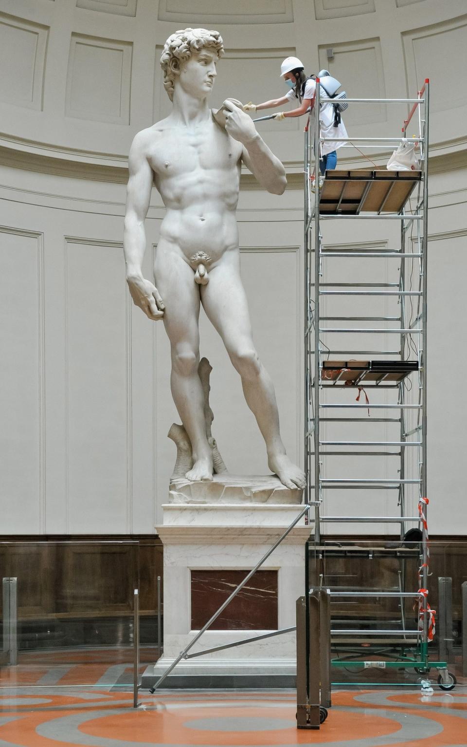 A restorer cleans Michelangelo's David statue while preparing for the reopening of the Galleria dell'Accademia which was closed for almost three months due to coronavirus  - Getty