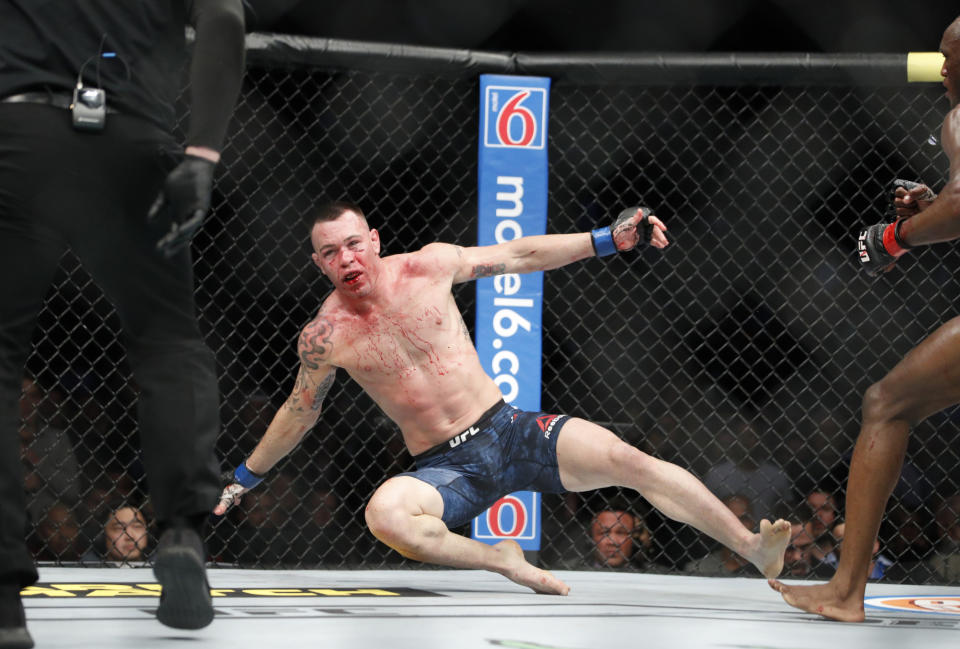 Kamaru Usman knocks Colby Covington to the mat in a mixed martial arts welterweight championship bout at UFC 245, Saturday, Dec. 14, 2019, in Las Vegas. (AP Photo/John Locher)