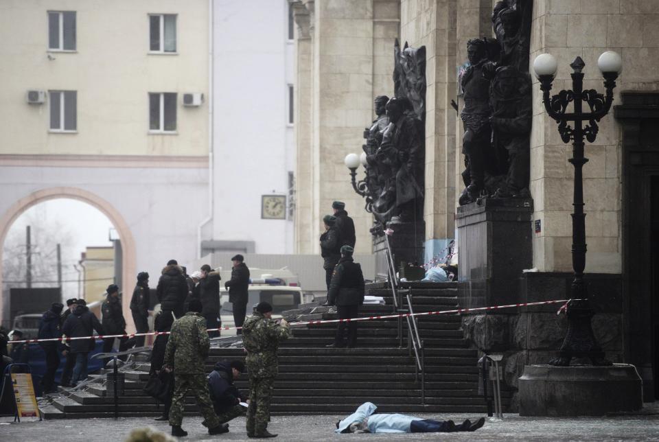 Investigators work near the body of a victim after an explosion outside a train station in Volgograd