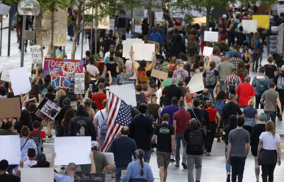 Protesters walk down the 16th Street mall during a protest over the death of George Floyd, a handcuffed black man who died in police custody in Minneapolis, Thursday, May 28, 2020, in Denver. Protesters walked from the Capitol down the 16th Street pedestrian mall. (AP Photo/David Zalubowski)