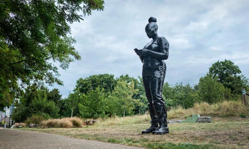 Black statue of girl with mobile phone