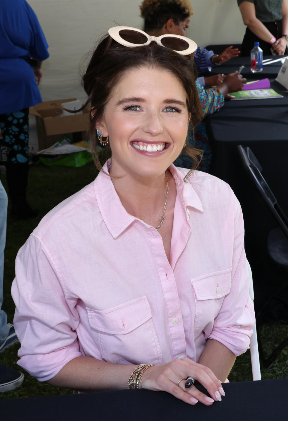 A closeup of Katherine Schwarzenegger smiling and holding a pen in her hand