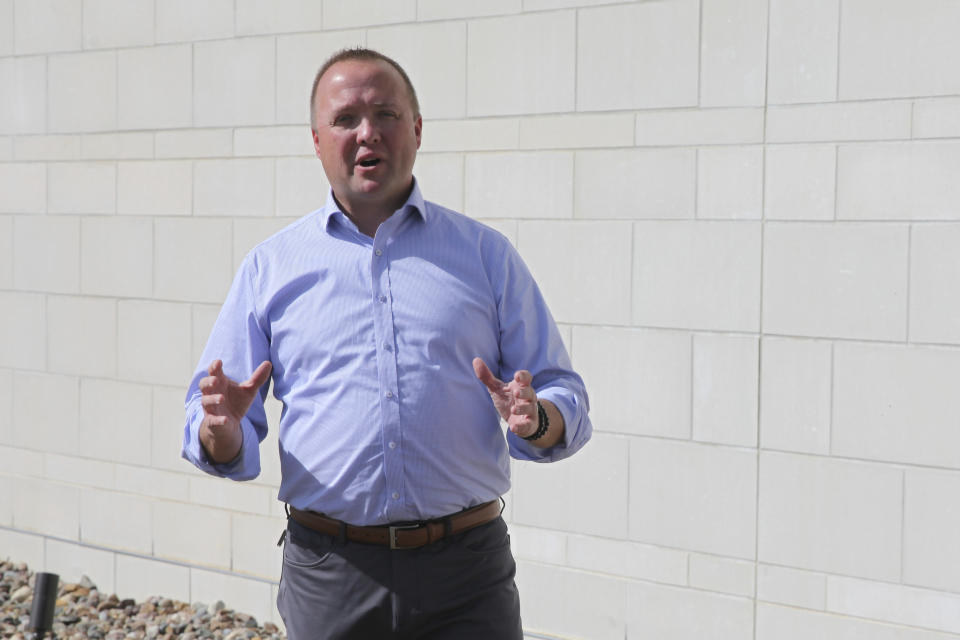 In this photo from Tuesday, Oct. 4, 2022, Chris Mann, the Democratic candidate for Kansas attorney general, answers questions as he stands out police headquarters in Lawrence, Kan. Mann is a former Lawrence police officer who was injured on duty and then became a local prosecutor and Mothers Against Drunk Driving national board member. (AP Photo/John Hanna)