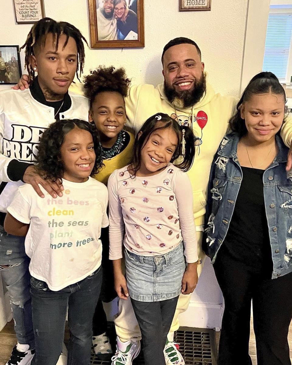 This photo provided by Gary Dameron shows his son, Gionni Dameron, top left, posing with his family in Des Moines, Iowa, in 2022. An 18-year-old who police say was involved in an ongoing gang dispute walked into the common area of an alternative education program for at-risk students and fatally shot two teenagers in a premeditated attack, including Gionni Dameron, according to a charging document released Tuesday, Jan 24, 2023. (Gary Dameron via AP)